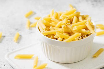 Pasta from durum wheat in a white bowl on a light table