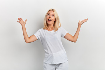 Fototapeta na wymiar Happy cheerful woman with raised arms looking up , being happy to achieve her goal, celebrating success isolated on white background, facial expression