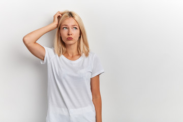 portrait of young puzzled woman scratching head, thinking about something,problem, isolated over white background. Human facial expression, emotion, feelings, signs symbols. copy space , idea, plan - obrazy, fototapety, plakaty