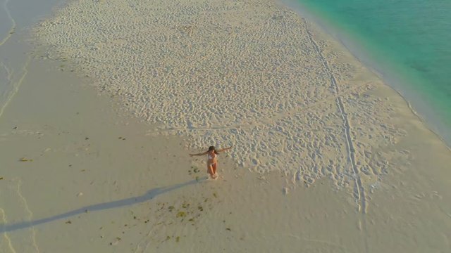  aerial view of a paradise woman alone on isolated white sandbar in Onok island in Balabac, Philippines