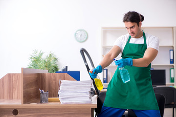 Young handsome contractor cleaning the office