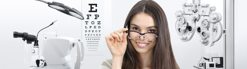 concept of eye examination, woman patient smiling with spectacles isolated in optician office with diagnostic tools on white background, prevention and control eyesight
