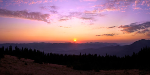 Rising sun with colorful skyline over the mountains in early morning