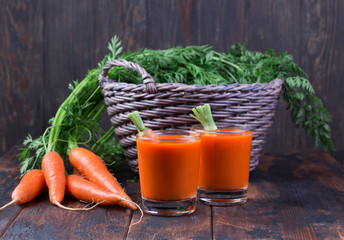 Fresh squeezed carrot juice on wooden background
