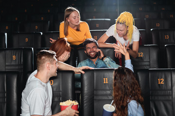 cheerful positive beaarded guy doesn't notice angry audience, he enjoying the cconversation at the cinema. close up photo