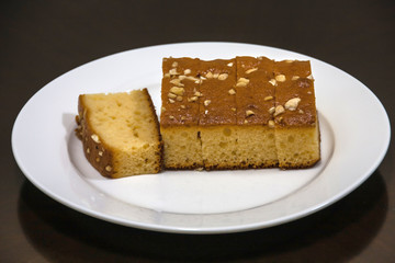A cut cake with cashew on a white plate