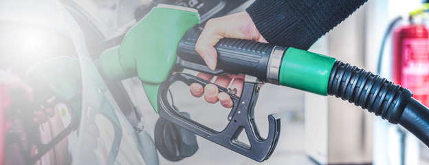 Woman pumping gasoline fuel in car at gas station. © Zedspider