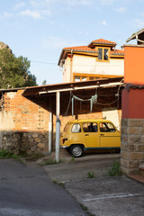 Old car parked close to village house  