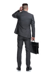 back view of a confused businessman scratching his head