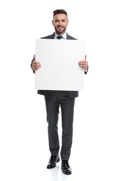 smiling young businessman showing a blank board