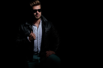 Fototapeta na wymiar sexy young modern man in leather jacket and sunglasses