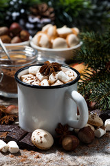 mug of hot chocolate with marshmallows and sweets on wooden table, vertical