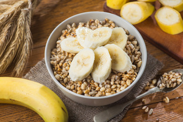 Sweet crispy granola in bowl with seeds and wheat, banana