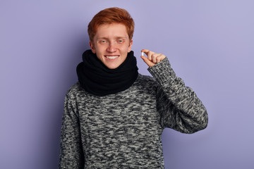 Cheerful excited young man standing and holding capsule. close up portrait, recovery concept. happiness