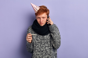 young sick pale man holding thermometer, making a phone call during his birthday, spoiled, the...