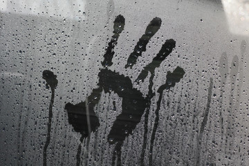 Imprint of a male hand on a car glass
