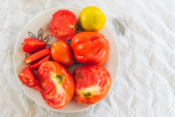 Freshly picked tomatoes, served on a plate on the table as decoration