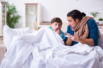 Obraz premium Young father caring for sick son