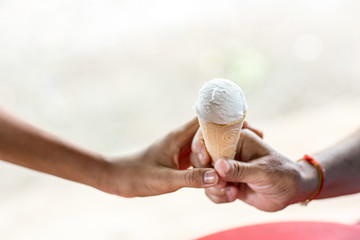 Hands give ice cream to Children. Share ice cream cone with children eating ice cream. Photo Concept Happiness only real when shared.