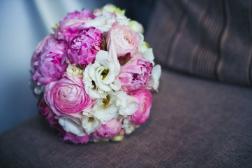 Wedding bouquet in pink, lies on the sofa