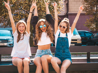 Portrait of three young beautiful smiling hipster girls in trendy summer clothes.Sexy carefree...