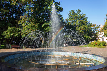 A fountain sprays water in sunny autumn weather.