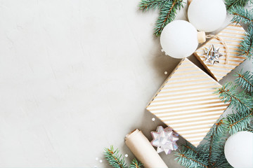 White Christmas background with Christmas tree branches, gift box and balls