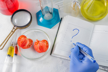 Close up of male scientist hands writing in notebook. GMO tests in the laboratory.