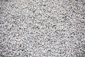 Texture of mill stones. Crushed stone building material. Gray motley background of stones.