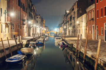 Fototapeta na wymiar Illuminated canal and pavement at night