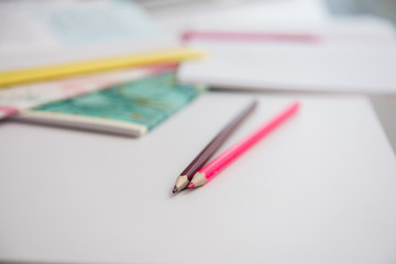 Fototapeta premium Focus on two pink colorful pencils at white desk