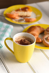 Breakfast in the cafe, coffee with croissant and cake