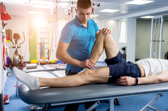 Rehabilitation Therapy. Physiotherapist Working With Young Male Patient In The Rehabilitation Center