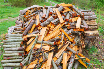 A lot of firewood stacked in a pile on the street