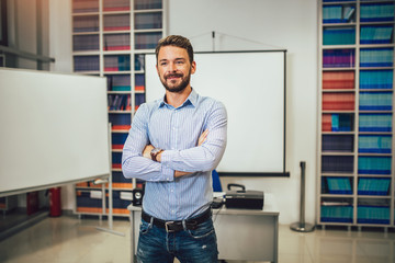 Smiling male coach giving presentation for audience in lecture hall