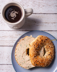 A delicious breakfast with an everything bagel, salmon spread and a cup of french press coffee.