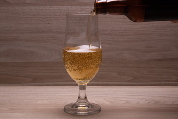 bottle pouring lager into glass