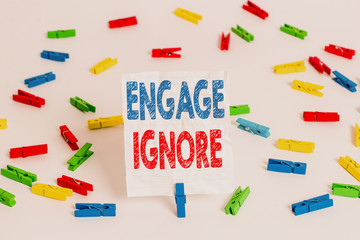 Text sign showing Engage Ignore. Business photo showcasing Silent Treatment Manipulative Punishment Sulking Shunning Colored clothespin papers empty reminder white floor background office
