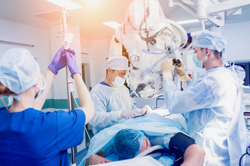 Spinal surgery. Group of surgeons in operating room with surgery equipment. Laminectomy