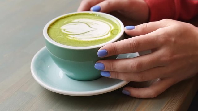 Matcha latte with vegetable milk in a blue mug.