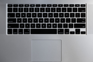silver laptop keyboard with black buttons close-up top view