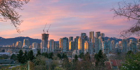 sun going down over skyline Vancouver downtown with the mountains of north Vancouver in the background