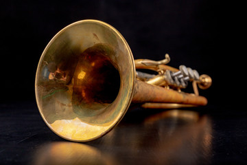 Trumpet covered with patina on a dark table. Neglected musical instrument.