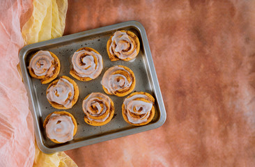 Baked cinnamon buns on steel baking tray.