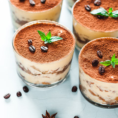 Tiramisu in the glass decorated whith mint on the wooden background