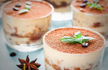 Tiramisu in the glass decorated whith mint on the wooden background