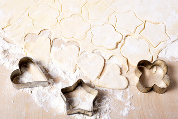 Cooking cookies in the shape of a heart, star and flower on a white wooden table