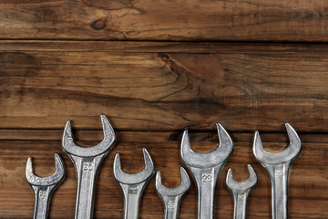set of wrenches on a wooden background, place for an inscription