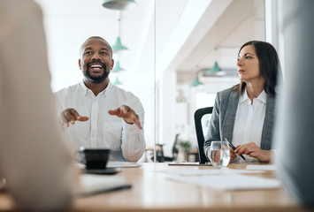 Smiling African American businessman talking with colleagues during a meeting