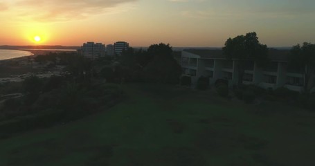 Aerial sunset view of Praia dos Tres Irmaos (Three Brothers beach) in Alvor, famous tourist destination in Western Algarve Coast, Portugal.